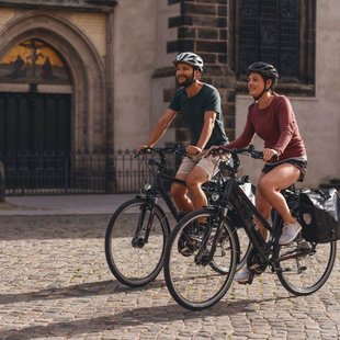 Radfahrer vor der Thesentür der Schlosskirche Wittenberg