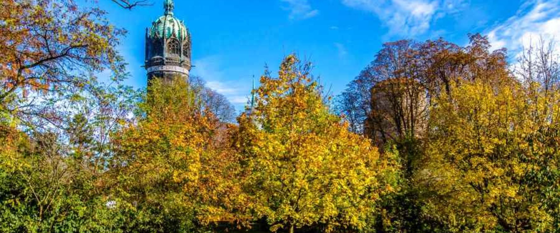 Schlosswiese mit Turm der Schlosskirche im Herbst
