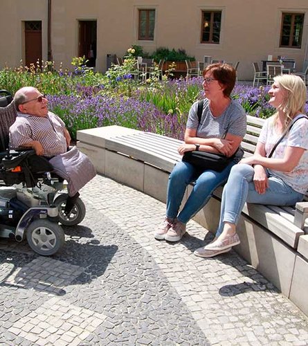 Mensch im Rollstuhl mit Freunden am Lutherhaus